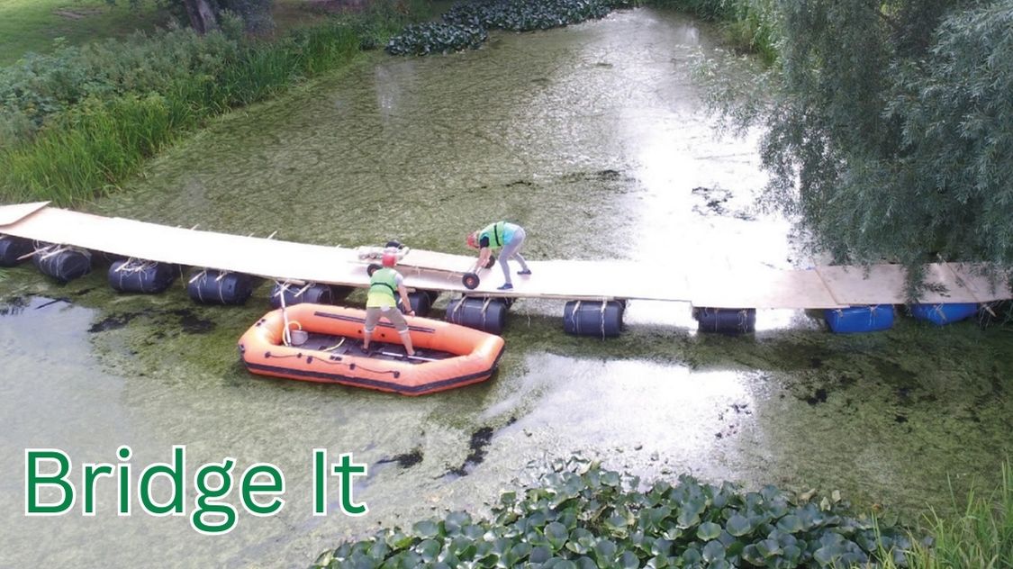 Billedet viser "Bridge It" aktiviteten, en populær teambuilding-udfordring, hvor deltagerne arbejder sammen om at konstruere en bæredygtig bro over et vandløb ved hjælp af forhåndsleverede materialer som træplanker og tønder. Dette er en fremragende øvelse i problemløsning og samarbejde, hvor teammedlemmer skal anvende både kreativ tænkning og fysisk dygtighed for at skabe en stabil og funktionel konstruktion. Aktiviteten er ideel til at styrke teamets dynamik og forbedre kommunikationen under pres.